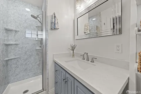 a bathroom with a granite countertop toilet sink and mirror