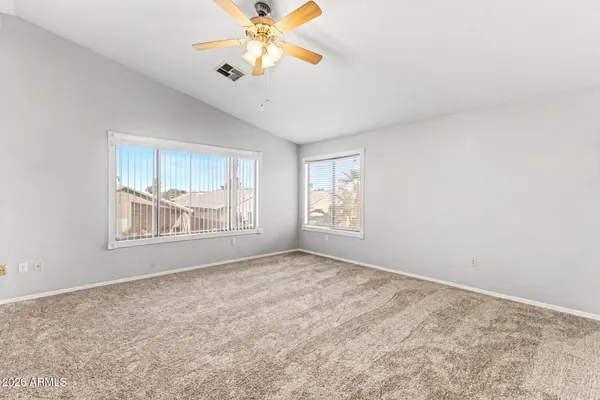 an empty room with windows and fan
