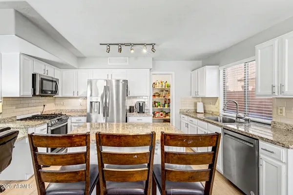 a kitchen with a dining table chairs and refrigerator