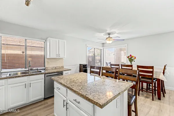 a kitchen with a table chairs and white cabinets