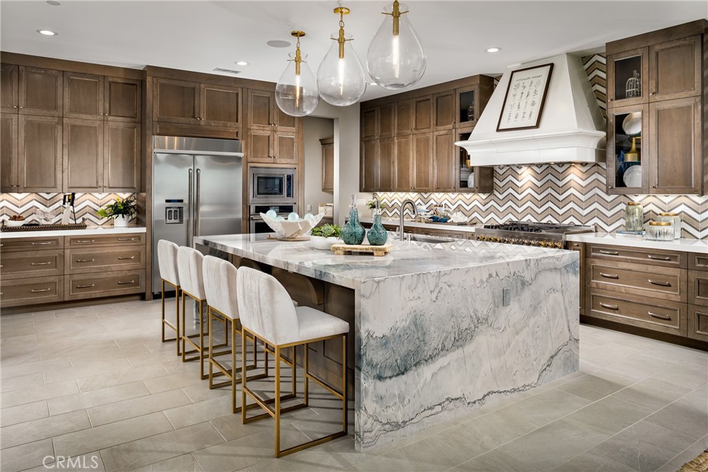 20320 Marlow Lane Porter Ranch, CA 91326 - Photo 5 of 16 a kitchen with stainless steel appliances kitchen island granite countertop a stove a sink and a refrigerator