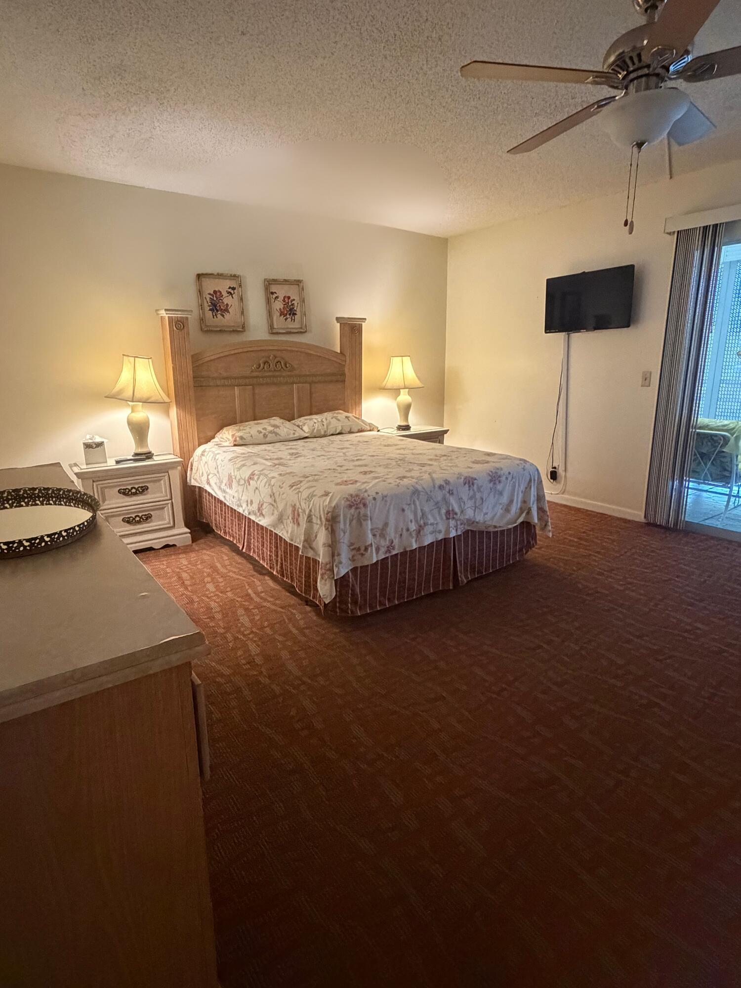 3058 Ainslie Drive, Unit 3058D Boca Raton, FL 33434 - Photo 1 of 13 a bedroom with a bed and a chandelier