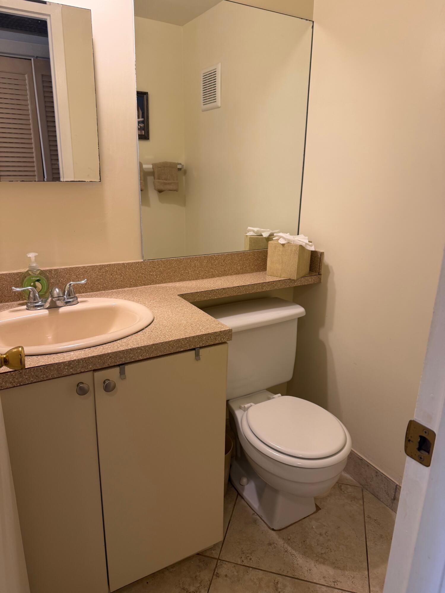 3058 Ainslie Drive, Unit 3058D Boca Raton, FL 33434 - Photo 9 of 13 a white toilet sitting next to a bathroom sink