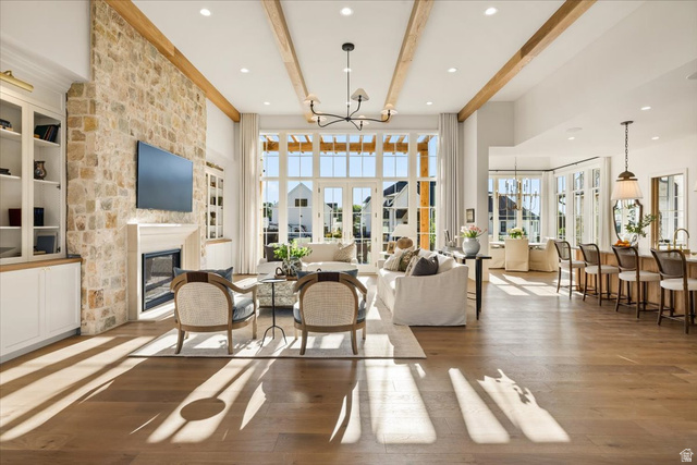478 South Maple Lakes Drive Mapleton, UT 84664 - Photo 15 of 51 Spacious living area featuring a stone accent wall with fireplace, recessed lighting, wood-finish flooring, exposed wood beams, and extensive natural light through large windows