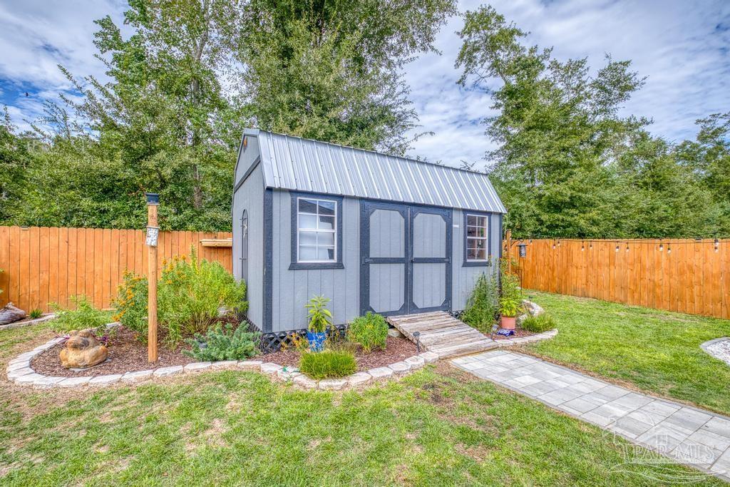 5277 Peach Drive Pace, FL 32571 - Photo 28 of 31 a view of a backyard with potted plants and large tree