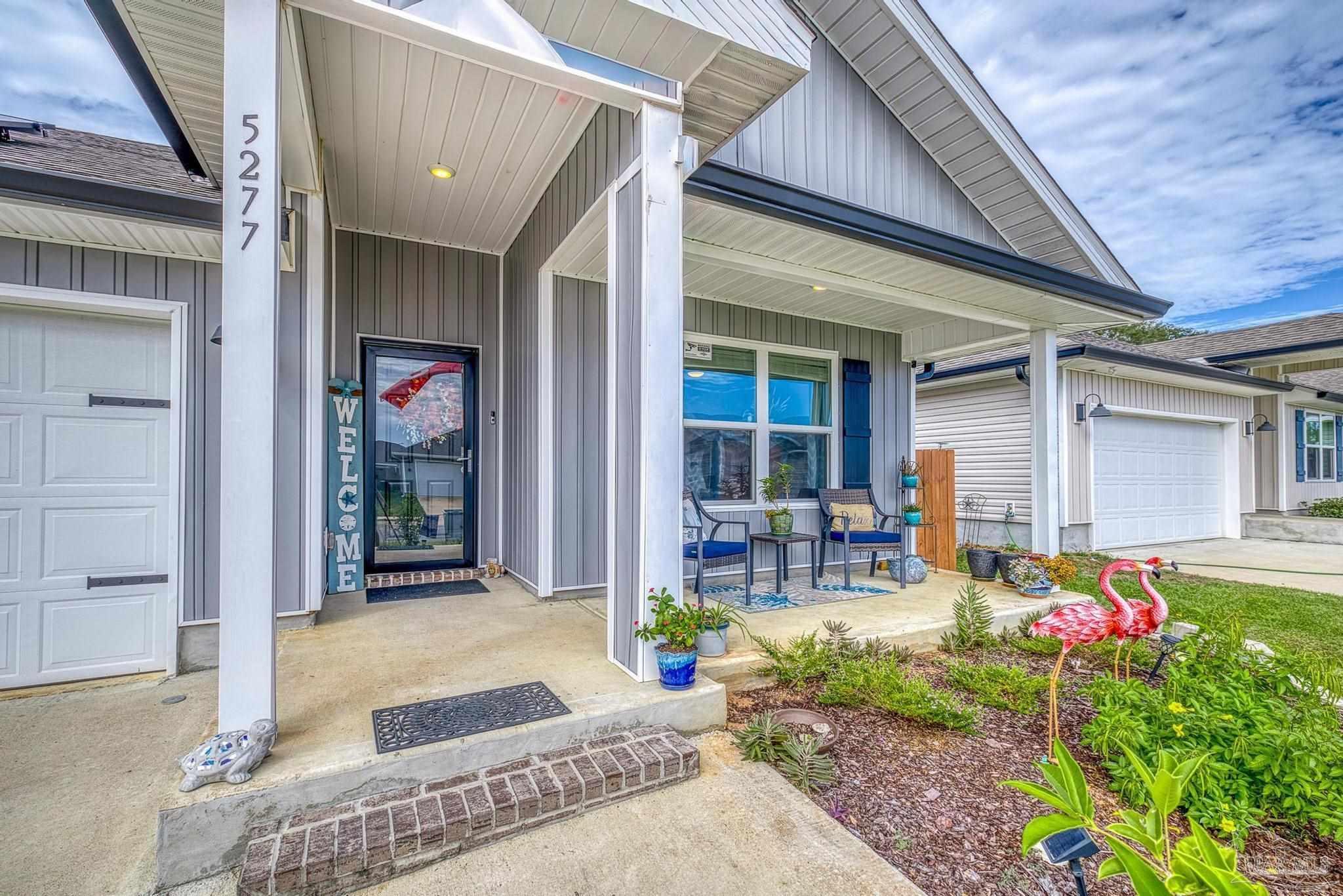 5277 Peach Drive Pace, FL 32571 - Photo 4 of 31 a front view of a house with outdoor seating and flowers
