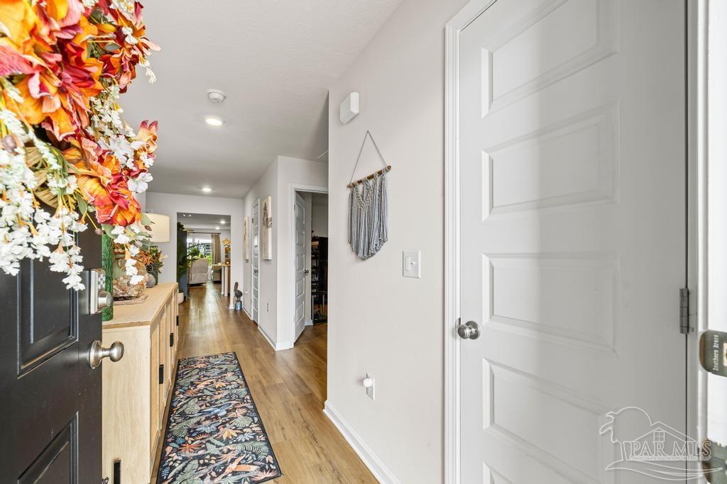 5277 Peach Drive Pace, FL 32571 - Photo 5 of 31 view of a hallway with wooden floor and staircase
