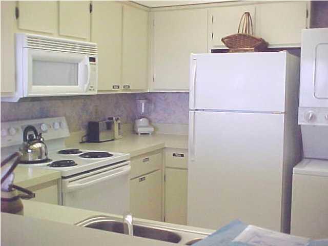 381 Santa Rosa Boulevard, Unit W515 Fort Walton Beach, FL 32548 - Photo 6 of 10 a kitchen with a refrigerator and a stove top oven