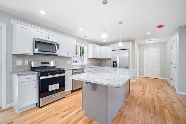 16 Ivan Springfield, MA 01104 - Photo 2 of 27 a kitchen with stainless steel appliances granite countertop a stove top oven a sink and a microwave