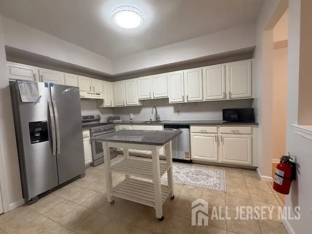 a kitchen with stainless steel appliances a refrigerator sink and cabinets
