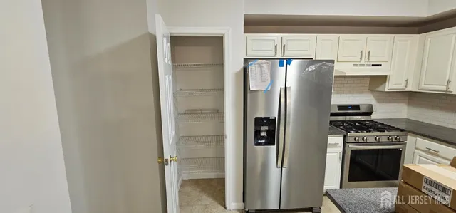 a kitchen with stainless steel appliances granite countertop a refrigerator and a stove