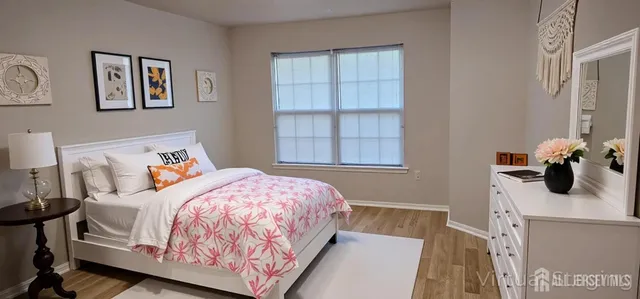 a bedroom with a bed and wooden floor