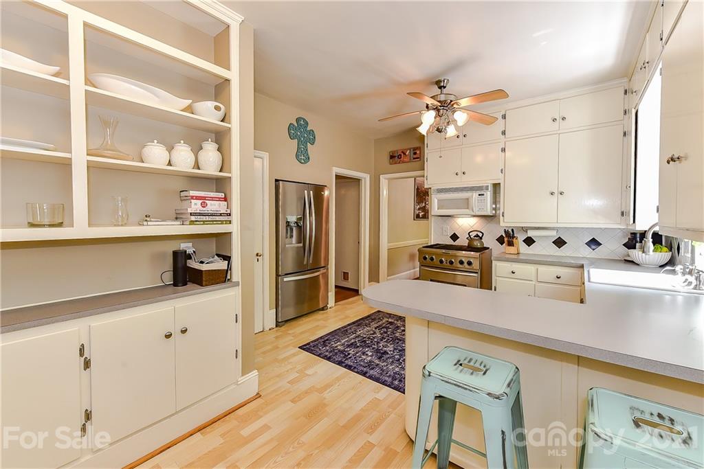 1405 Lilac Road Charlotte, NC 28209 - Photo 11 of 39 a kitchen with stainless steel appliances granite countertop a sink a stove and a refrigerator