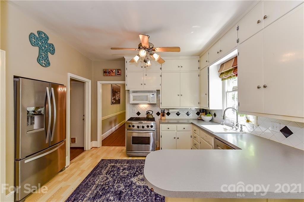 1405 Lilac Road Charlotte, NC 28209 - Photo 12 of 39 a kitchen with stainless steel appliances granite countertop a sink stove and refrigerator