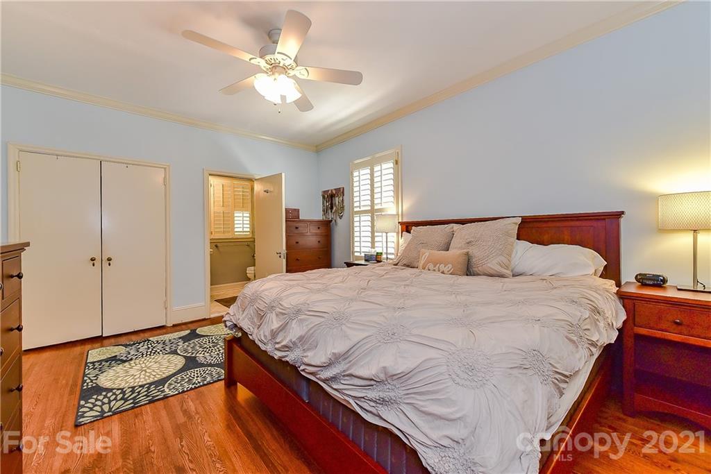 1405 Lilac Road Charlotte, NC 28209 - Photo 17 of 39 a bedroom with a bed and a chandelier