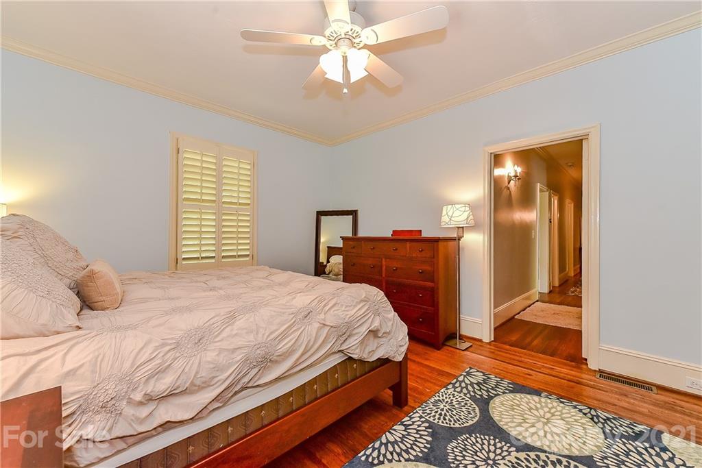 1405 Lilac Road Charlotte, NC 28209 - Photo 19 of 39 a bedroom with a bed and a chandelier fan