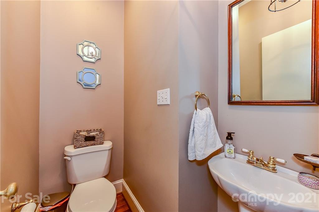 1405 Lilac Road Charlotte, NC 28209 - Photo 22 of 39 a bathroom with a toilet a sink and mirror