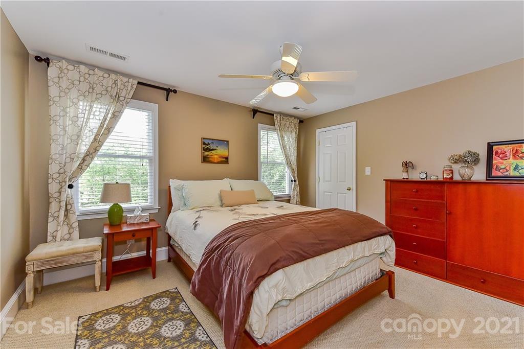 1405 Lilac Road Charlotte, NC 28209 - Photo 24 of 39 a bedroom with a bed and a chandelier
