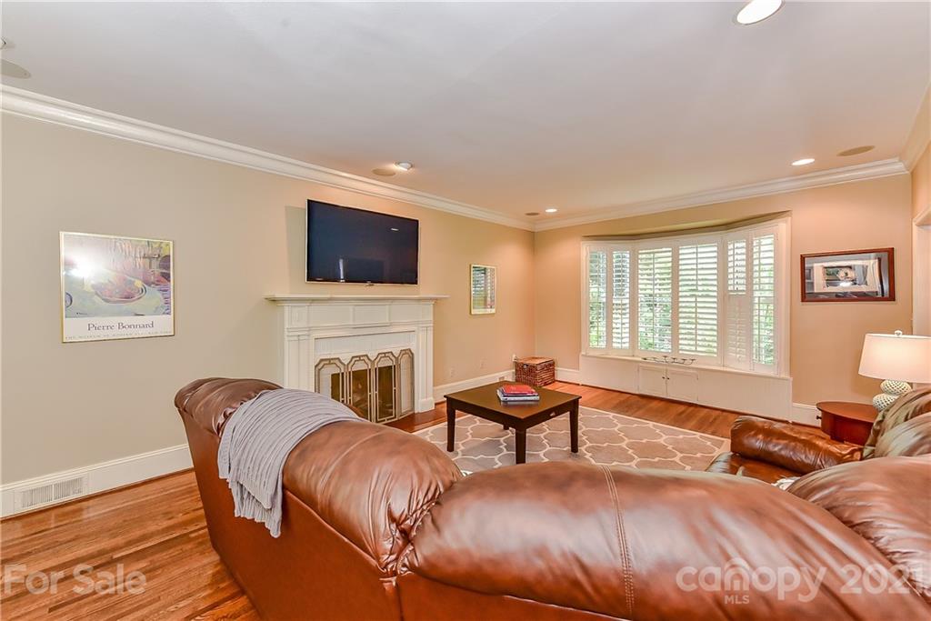 1405 Lilac Road Charlotte, NC 28209 - Photo 4 of 39 a living room with furniture a fireplace and a flat screen tv