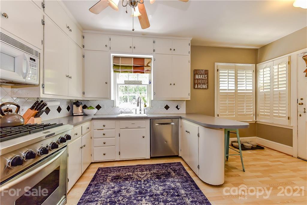1405 Lilac Road Charlotte, NC 28209 - Photo 10 of 39 a kitchen with granite countertop a sink a counter space appliances and cabinets