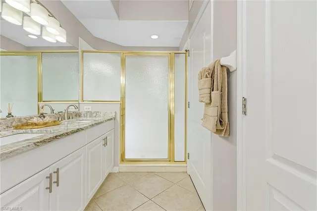 a bathroom with a granite countertop sink a mirror and a shower
