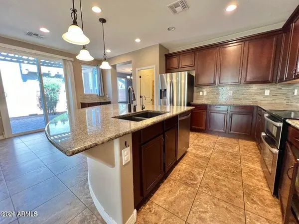 a kitchen with stainless steel appliances granite countertop a sink counter space cabinets and a large window
