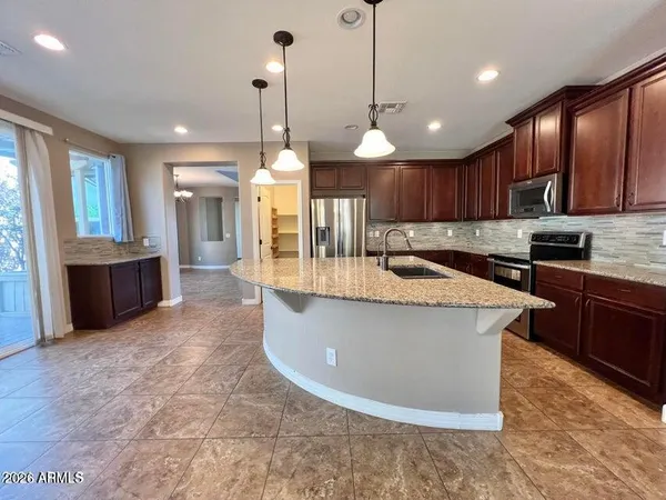 a kitchen with kitchen island a island a sink stainless steel appliances and a counter top space