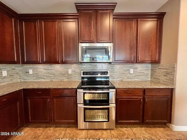 a kitchen with granite countertop wood cabinets and stainless steel appliances