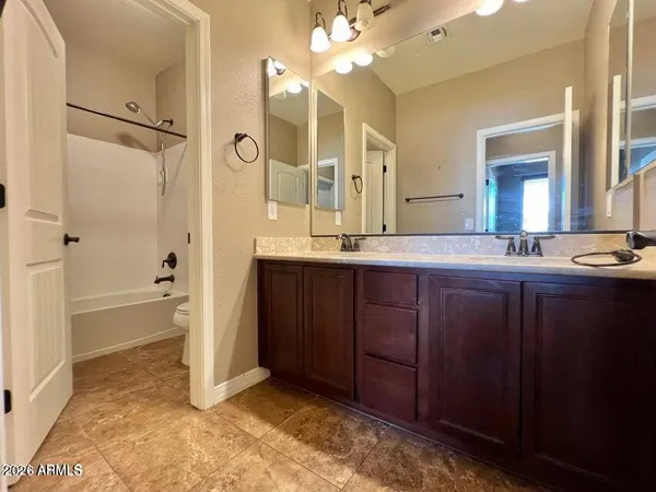 a bathroom with a granite countertop sink mirror and a bathtub