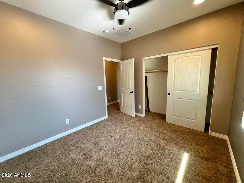 3886 East Rawhide Street Gilbert, AZ 85296 - Photo 31 of 52 an empty room with closet and a ceiling fan