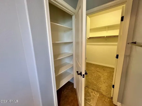 a view of walk in closet with empty racks