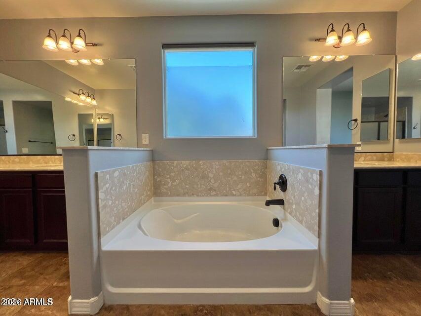 3886 East Rawhide Street Gilbert, AZ 85296 - Photo 38 of 52 a bathroom with a bathtub a mirror and a shower