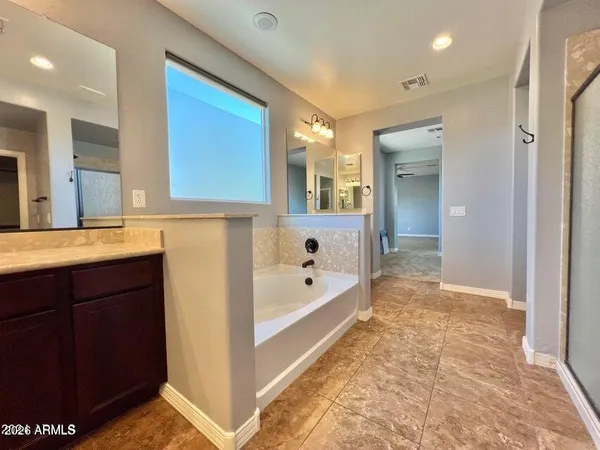 a spacious bathroom with a tub sink and mirror