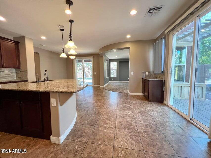 3886 East Rawhide Street Gilbert, AZ 85296 - Photo 8 of 52 an open kitchen with a sink and chandelier