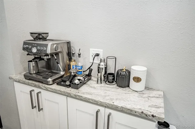 a kitchen with a sink and a stove with white cabinets