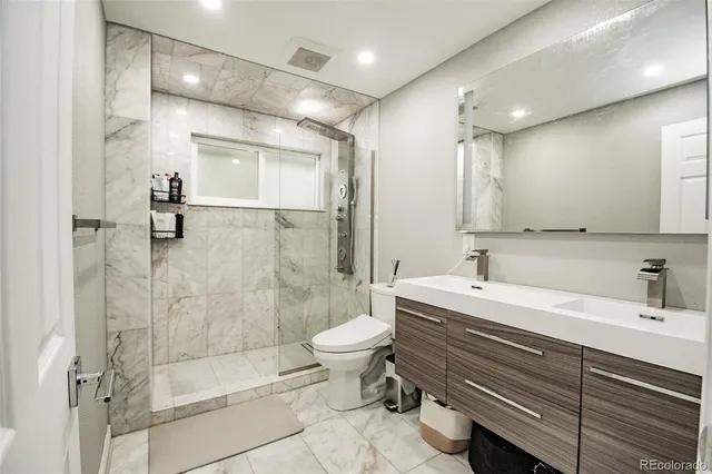 a bathroom with a sink a toilet and shower