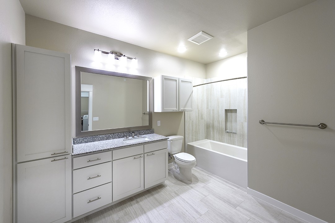 1724 Partnership Way, Unit 2102 Katy, TX 77449 - Photo 28 of 33 a bathroom with a granite countertop sink toilet mirror and bathtub
