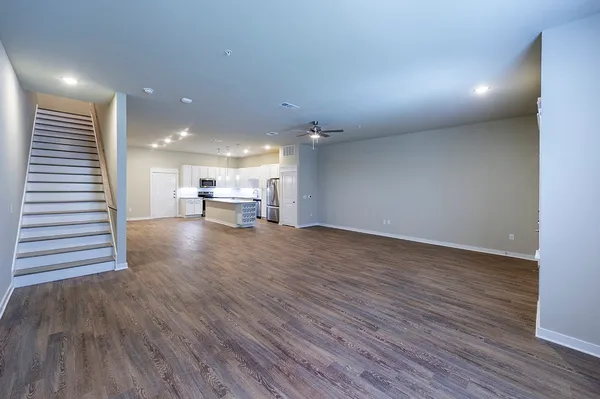 a large kitchen with stainless steel appliances granite countertop a large counter top and a stove with wooden floors