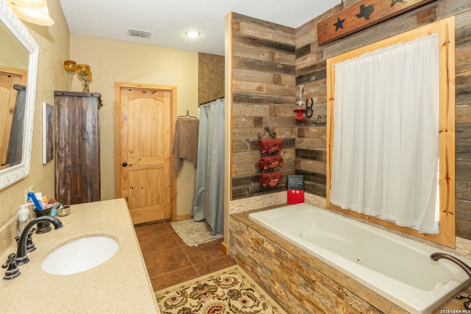 1079 County Road 357 Utopia, TX 78884 - Photo 15 of 36 a bathroom with a granite countertop sink and a mirror