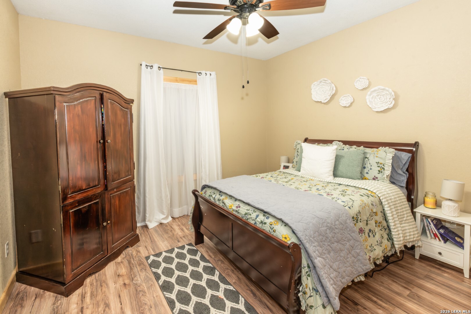1079 County Road 357 Utopia, TX 78884 - Photo 9 of 36 a bedroom with a bed and a chandelier
