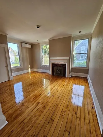 a view of empty room with wooden floor and fireplace