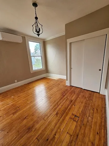 a view of empty room with wooden floor and window