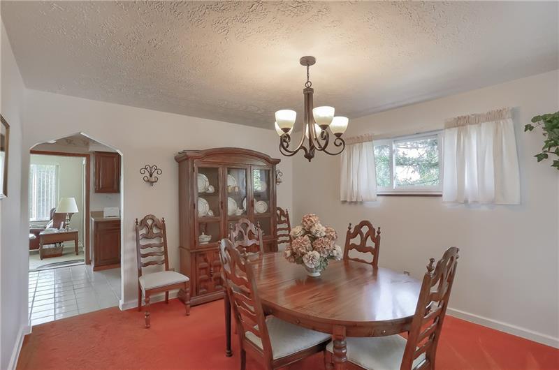 The elegant dining room is accessible to the kitchen and features abundant natural sunlight.