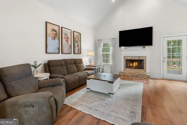 a living room with furniture a fireplace and a flat screen tv