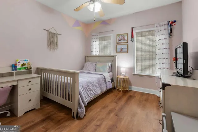 a bedroom with a bed and a flat tv screen on dresser