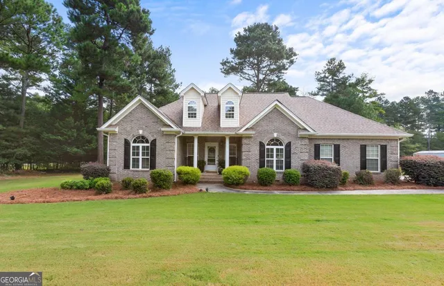 a view of a backyard with table and chairs potted plants with large tree