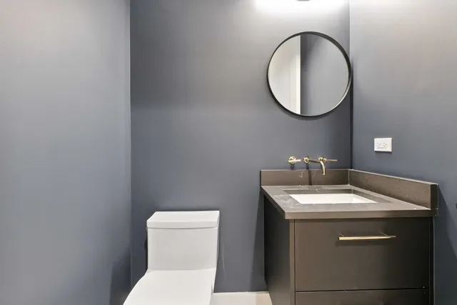 a bathroom with a toilet a sink and a mirror