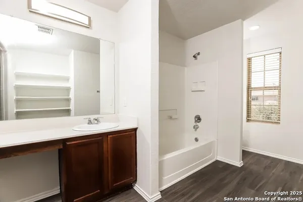a bathroom with a tub sink and mirror
