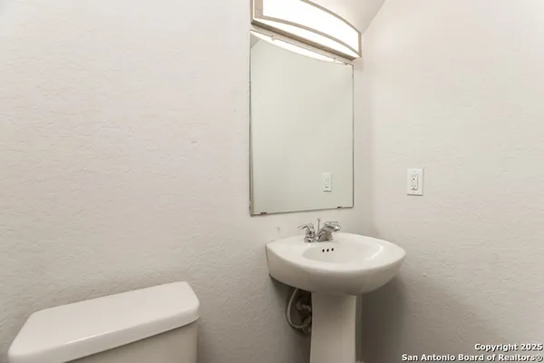 a bathroom with a toilet sink and mirror