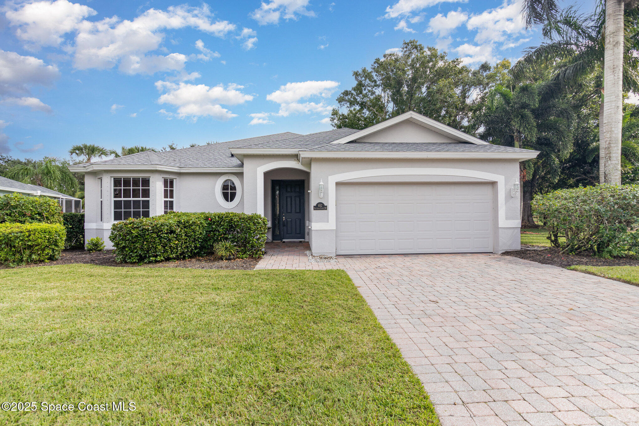 652 Hatteras Court Southwest Vero Beach, FL 32968 - Photo 1 of 48 a front view of a house with yard and trees